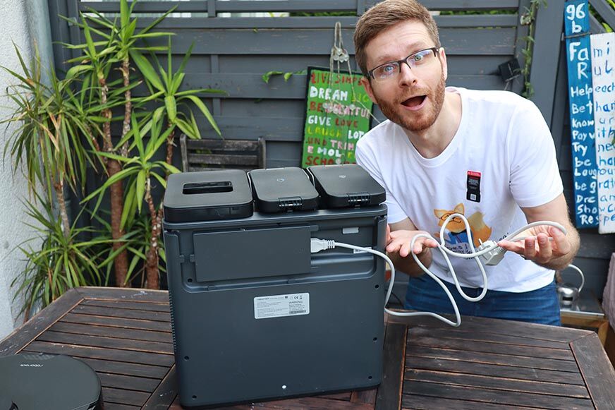 The white power cable of the Roborock S7 MaxV Ultra Station is held in the hands.